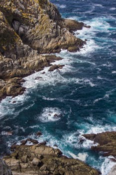 A captivating view of the rugged coastline in Pontevedra, showcasing rocky cliffs and vibrant blue waters.