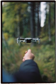A drone in flight captured in a lush forest environment, emphasizing technology and nature.