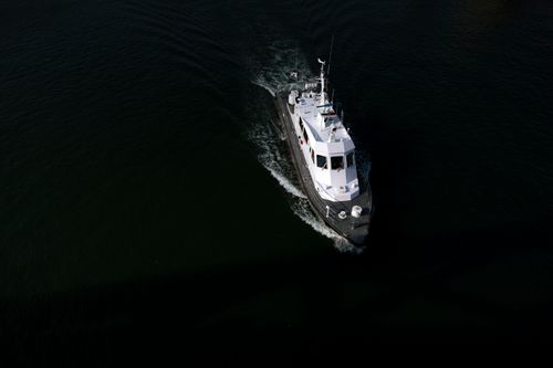Free Aerial shot of a boat navigating dark waters in Sokcho, South Korea. Stock Photo
