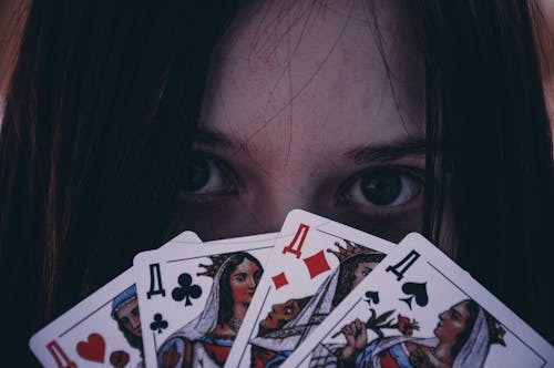 Girl Holding Playing Cards in front of her Face 