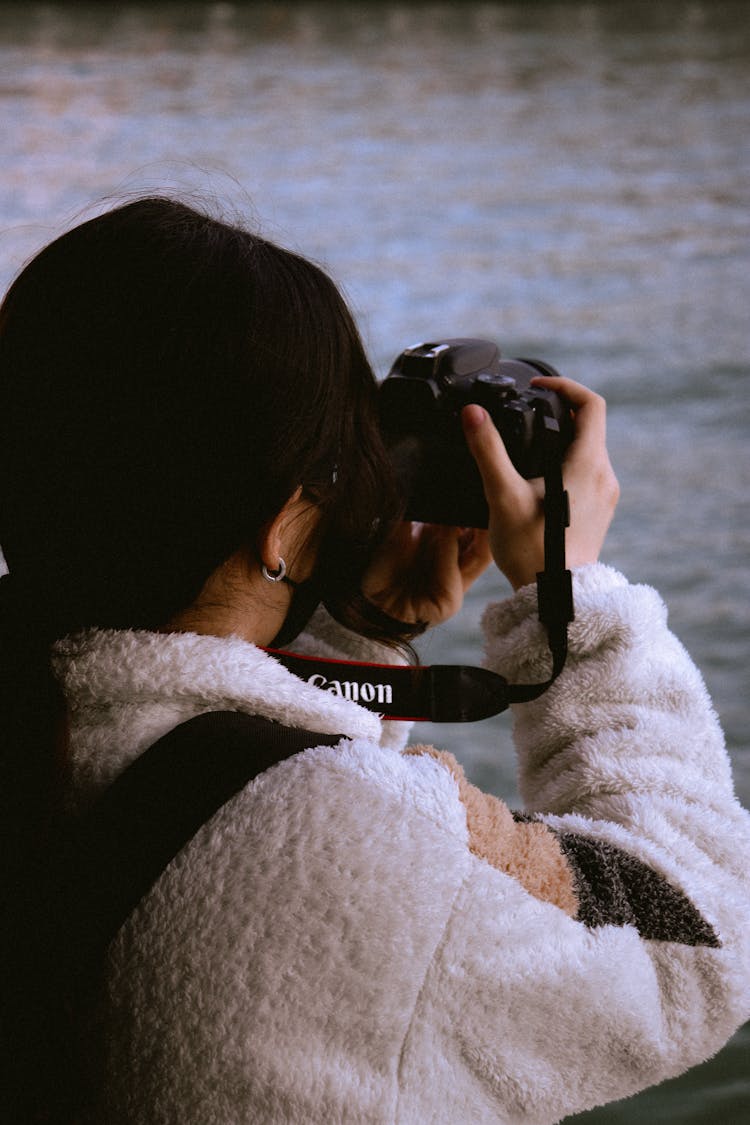 Woman Wearing Fleece Sweater Holding A Black Camera