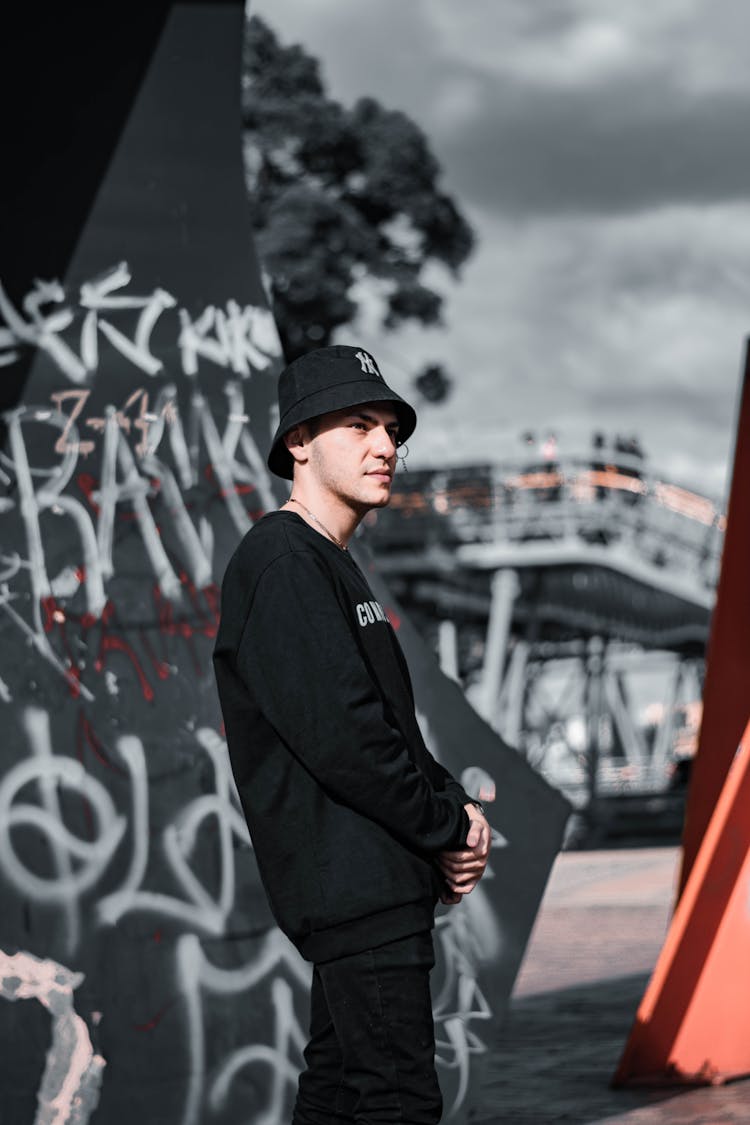 Man In Black Clothes Posing Near Graffiti Wall