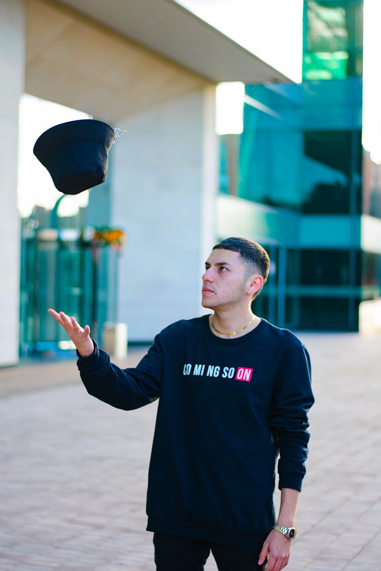 A Man Throwing A Bucket Hat In The Air 