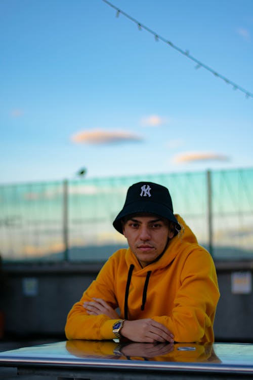 A Man in Yellow Hoodie Wearing a Black Bucket Hat