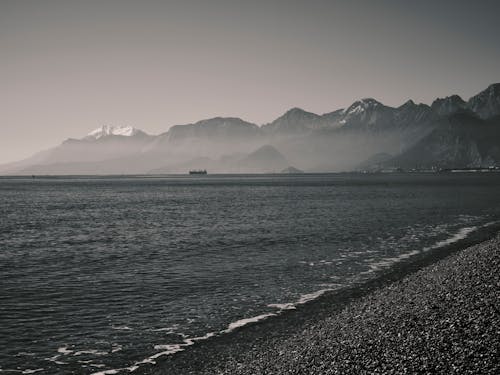 Black and White Photo of Sea and Mountains