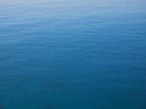 Tranquil blue ocean surface reflecting sunlight, showcasing a serene seascape.