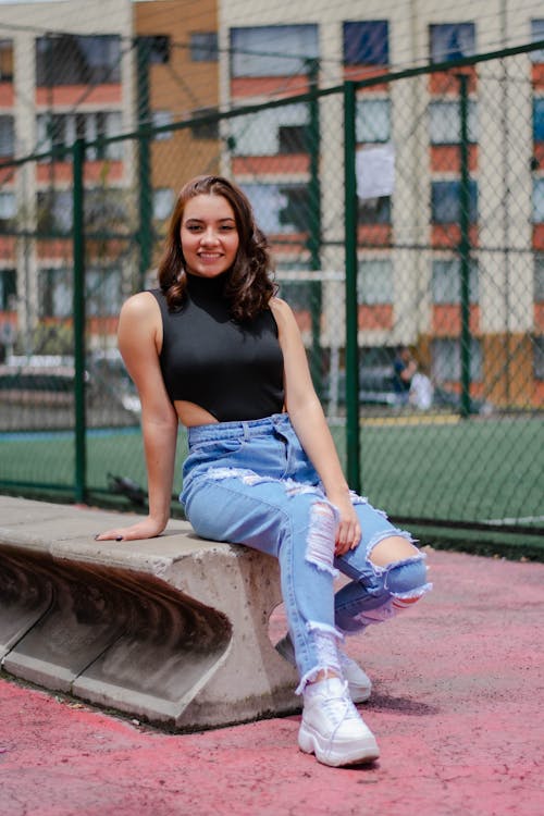 Beautiful Woman Wearing a Black Bodysuit and Ripped Jeans