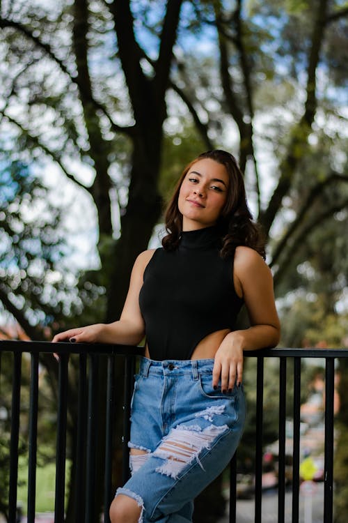 Woman Wearing a Black Bodysuit and Ripped Jeans