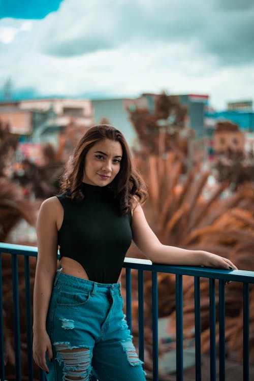 Beautiful Woman Wearing a Black Sleeveless Bodysuit and Ripped Jeans