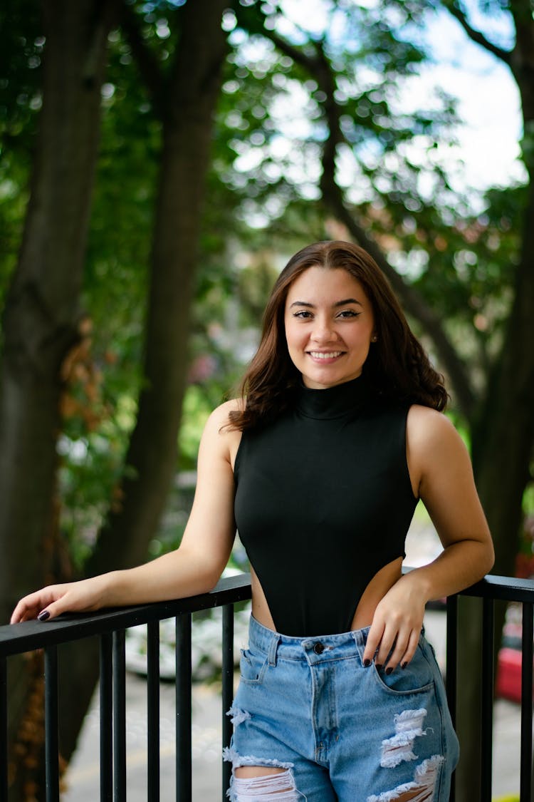 Smiling Woman Leaning On Balcony Railing