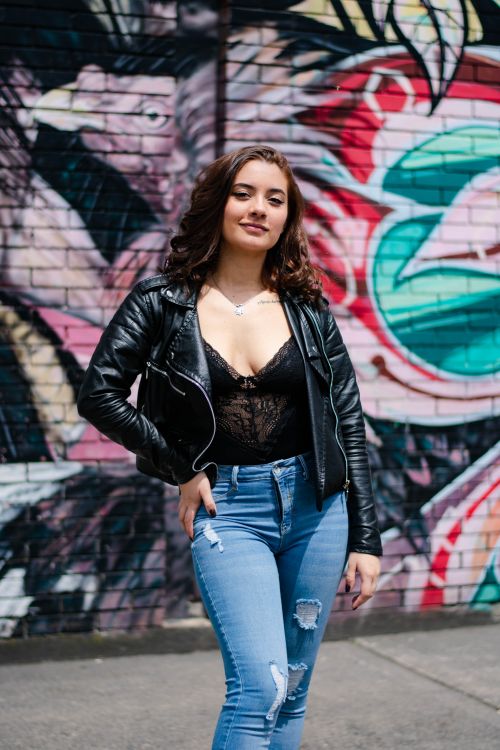 Woman in black leather jacket and blue denim jeans