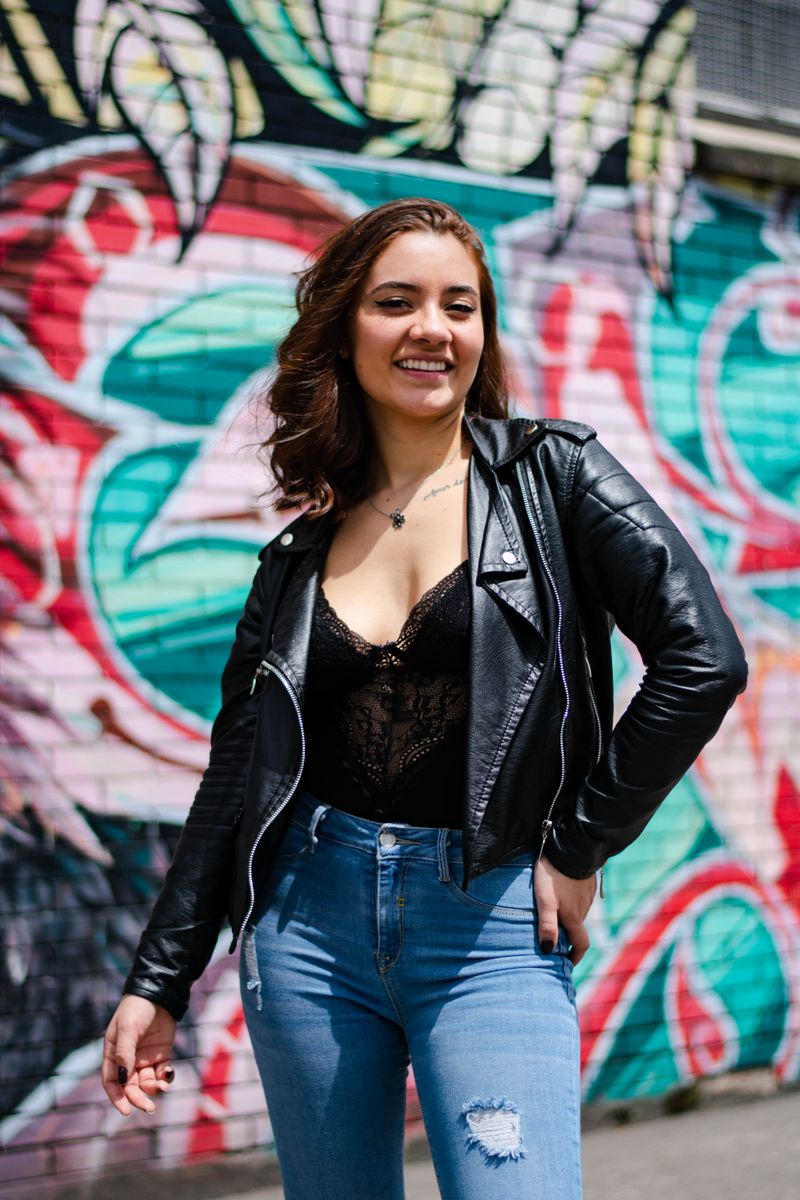 Woman in black leather jacket and blue denim jeans, casual Friday office outfit