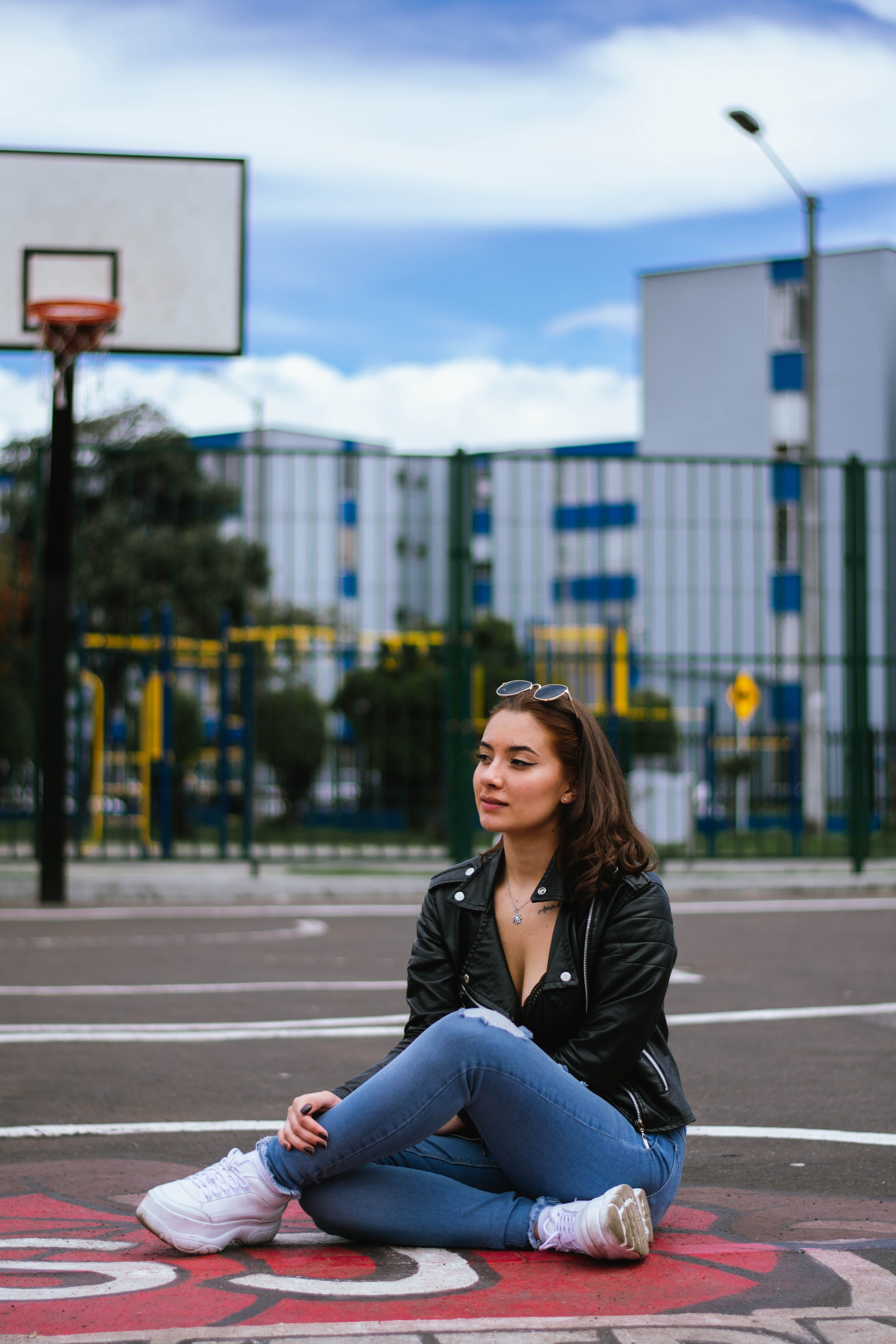 Woman in Black Leather Jacket and Blue Denim Jeans Sitting on the ...