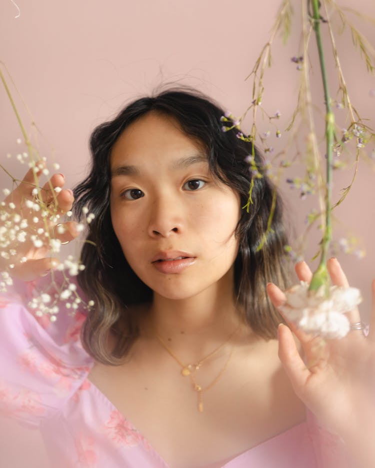 Woman In Pink Touching Hanging White Flowers