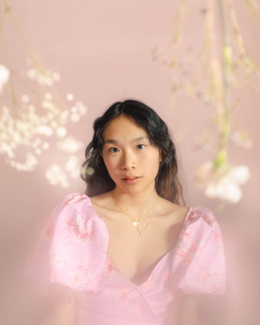 Beautiful portrait of an elegant woman in a floral dress with soft lighting and warm tones.