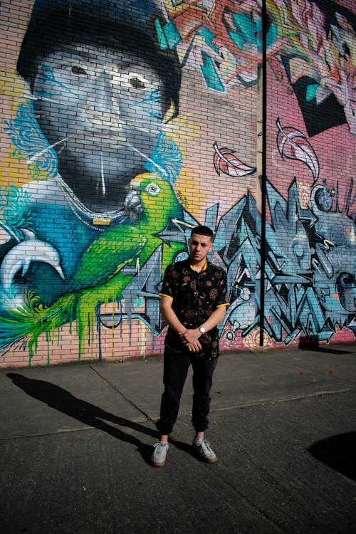 Man Standing in front of Graffiti Wall