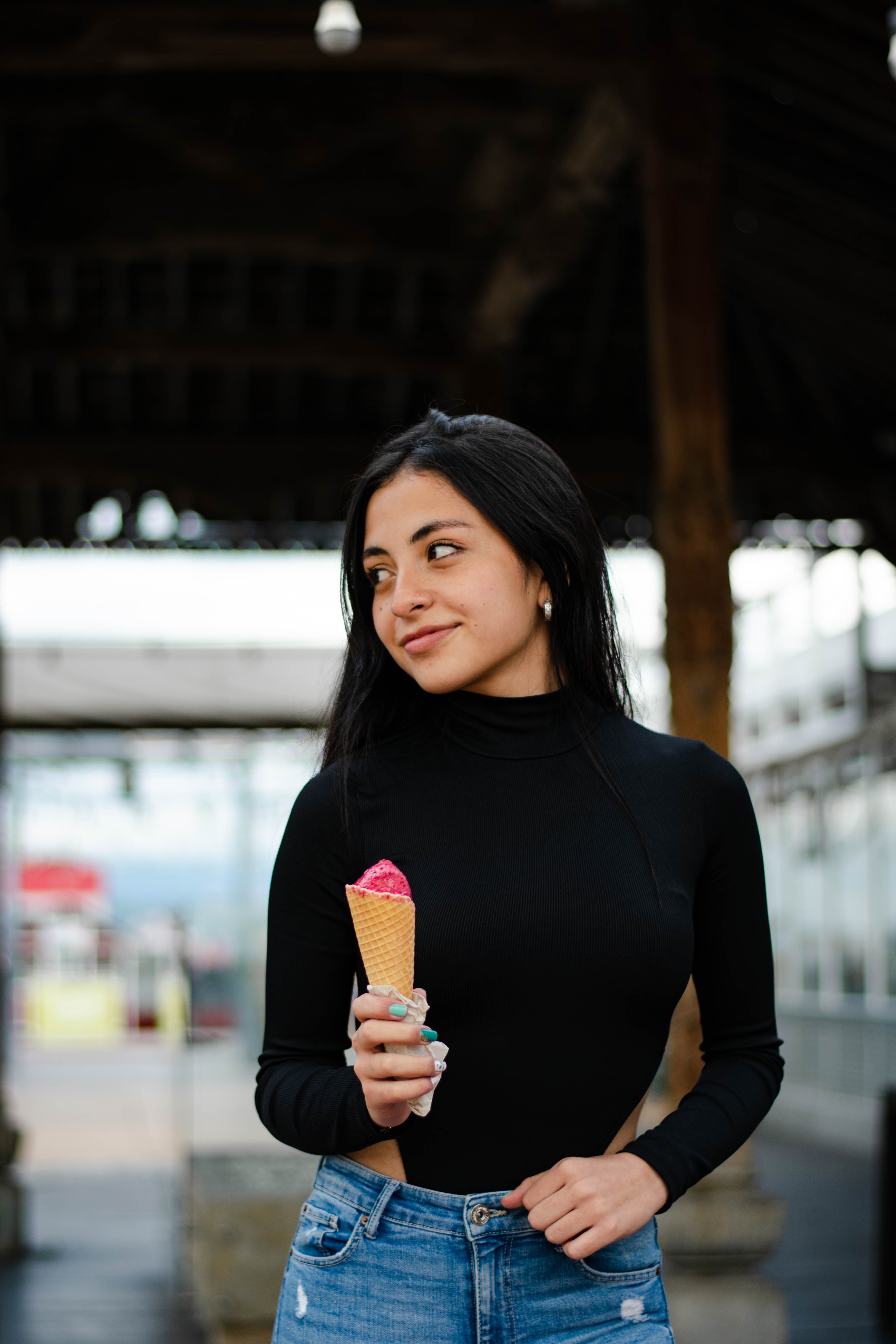 Young Woman in Black Long Sleeves Shirt Holding an Ice Cream Cone while ...