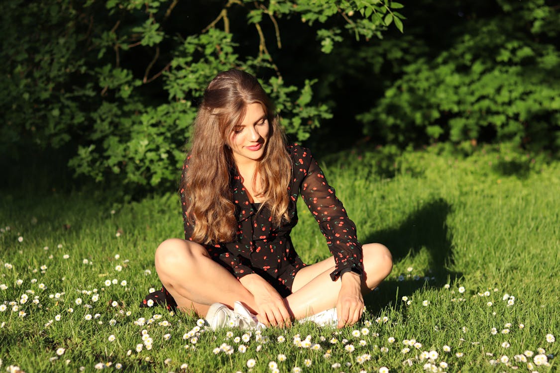 Vrouw Draagt Rood En Bruin Mesh Overhemd Zit Op Witte Bloem Veld