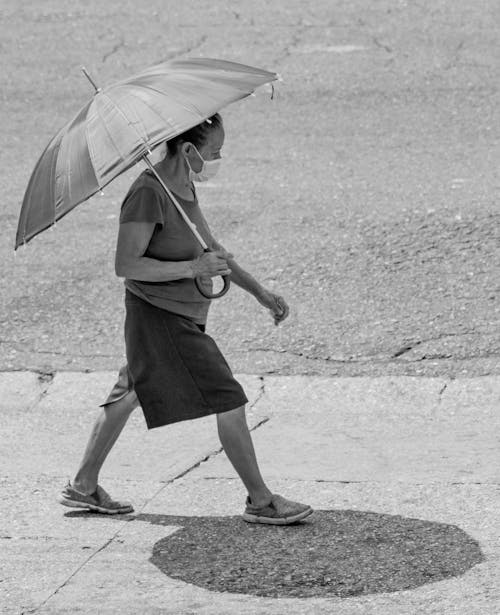 Foto profissional grátis de andando, escala de cinza, guarda-chuva