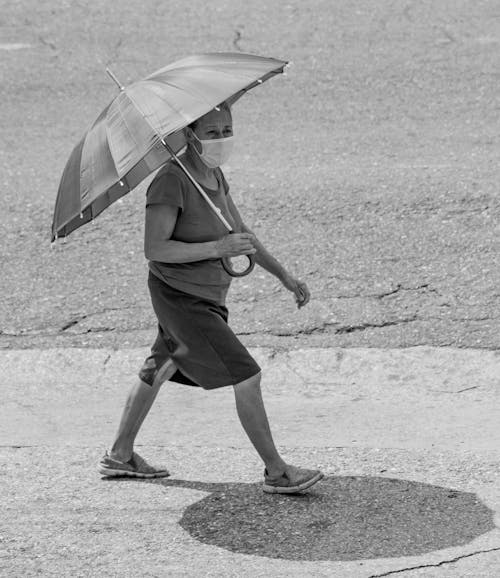 Foto profissional grátis de andando, escala de cinza, guarda-chuva