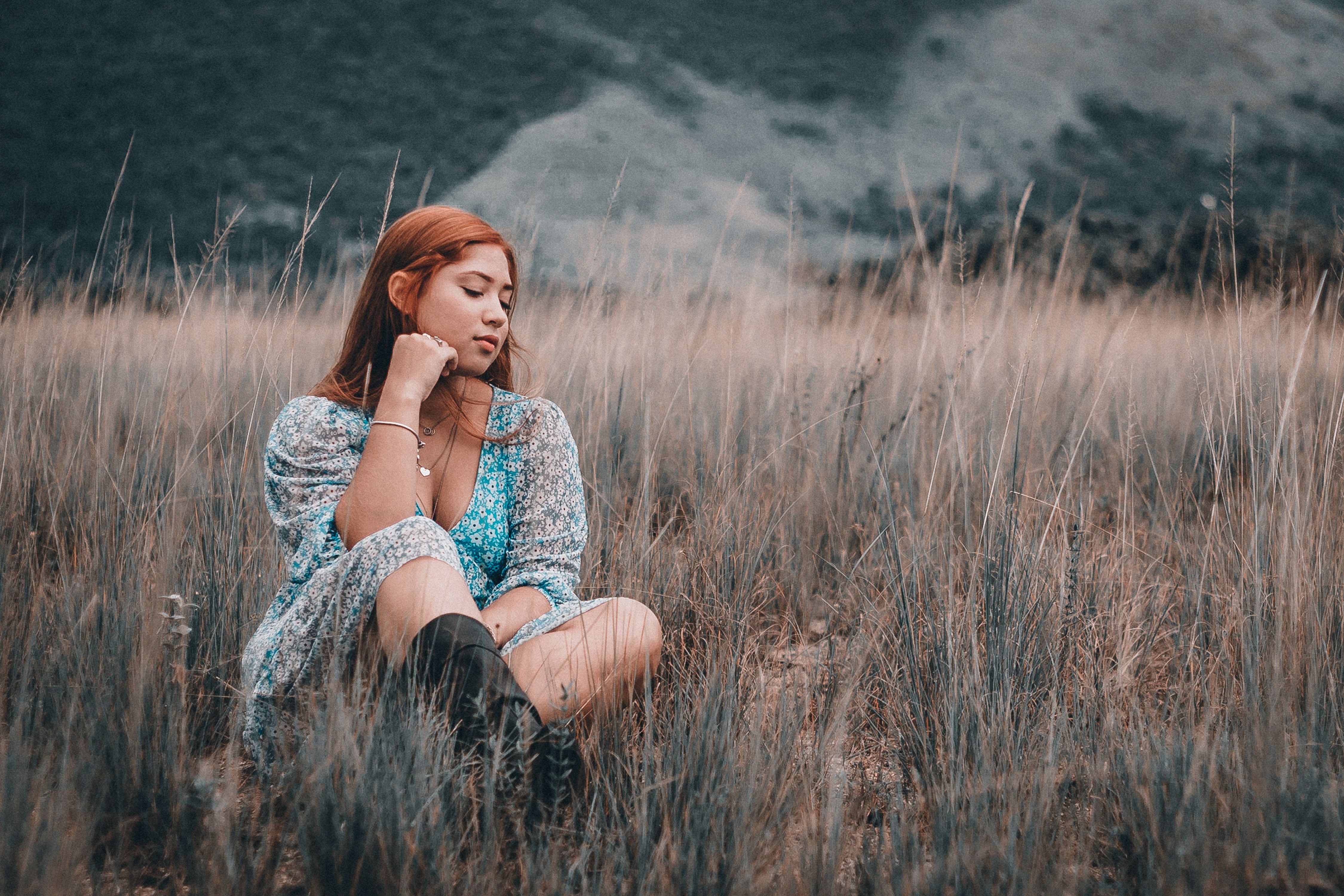 Woman in Floral Dress Sitting on Grass Field · Free Stock Photo