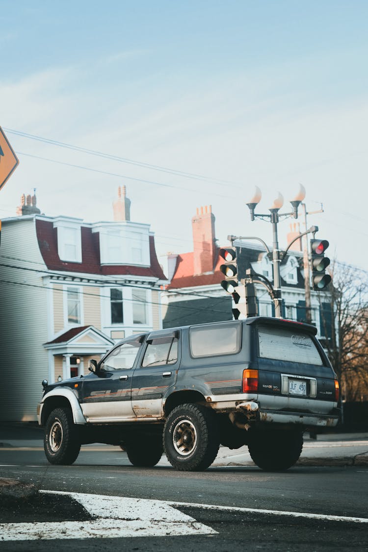 Off-Road Car Stopped By Red Traffic Light In Town Street