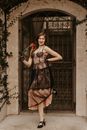 Smiling Woman Wearing Vintage Dress with Red Rose in Hand