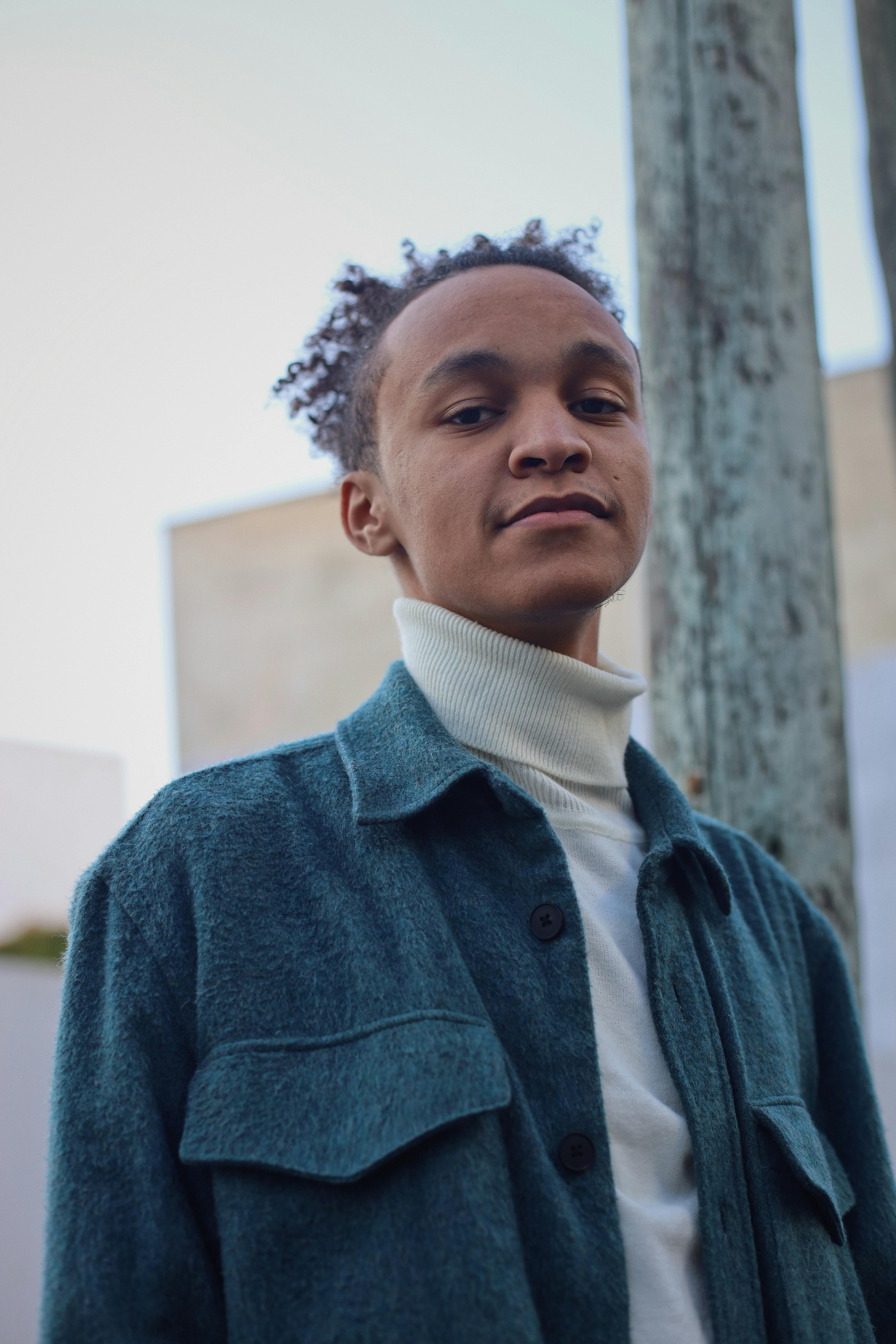 Low angle portrait of a well-dressed young man outdoors, exuding confidence and style.