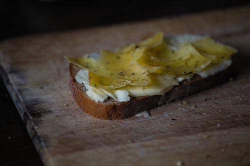 Free A Bread with Cheese Toppings on a Wooden Surface Stock Photo