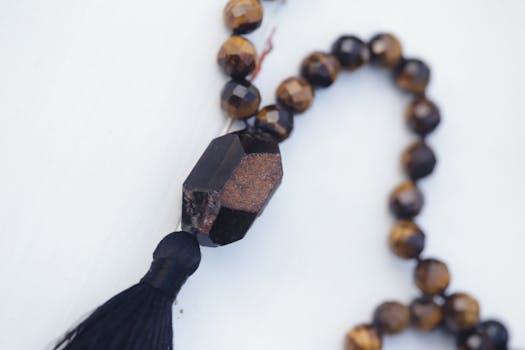 Close-up of a stylish beaded necklace with tassel on a white background.
