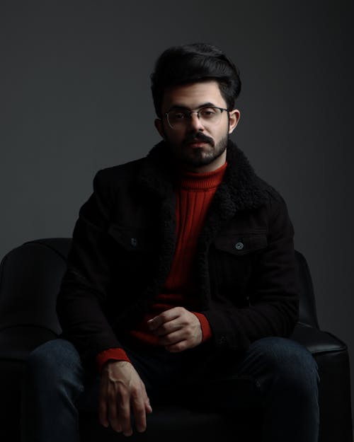 Man in Black Jacket Sitting on a Black Leather Armchair 