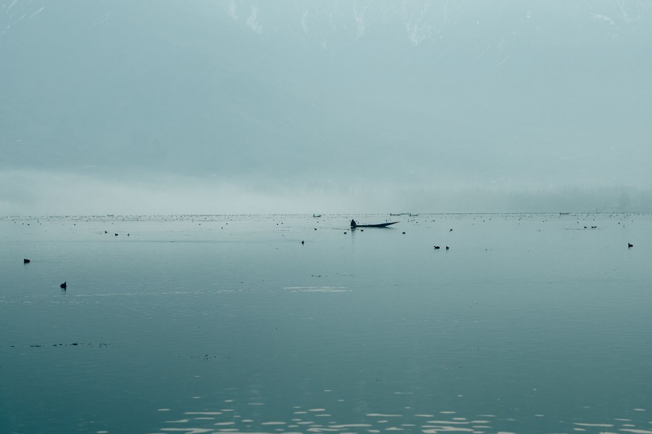 calm foggy lake with a lone boat evoking serenity and peace