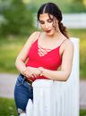 Woman in Red Top Leaning on White Fence
