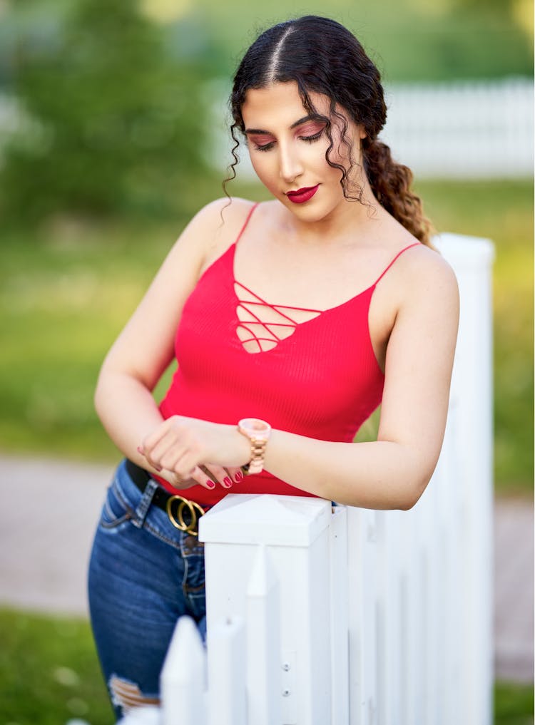 Woman In Red Top Leaning On White Fence