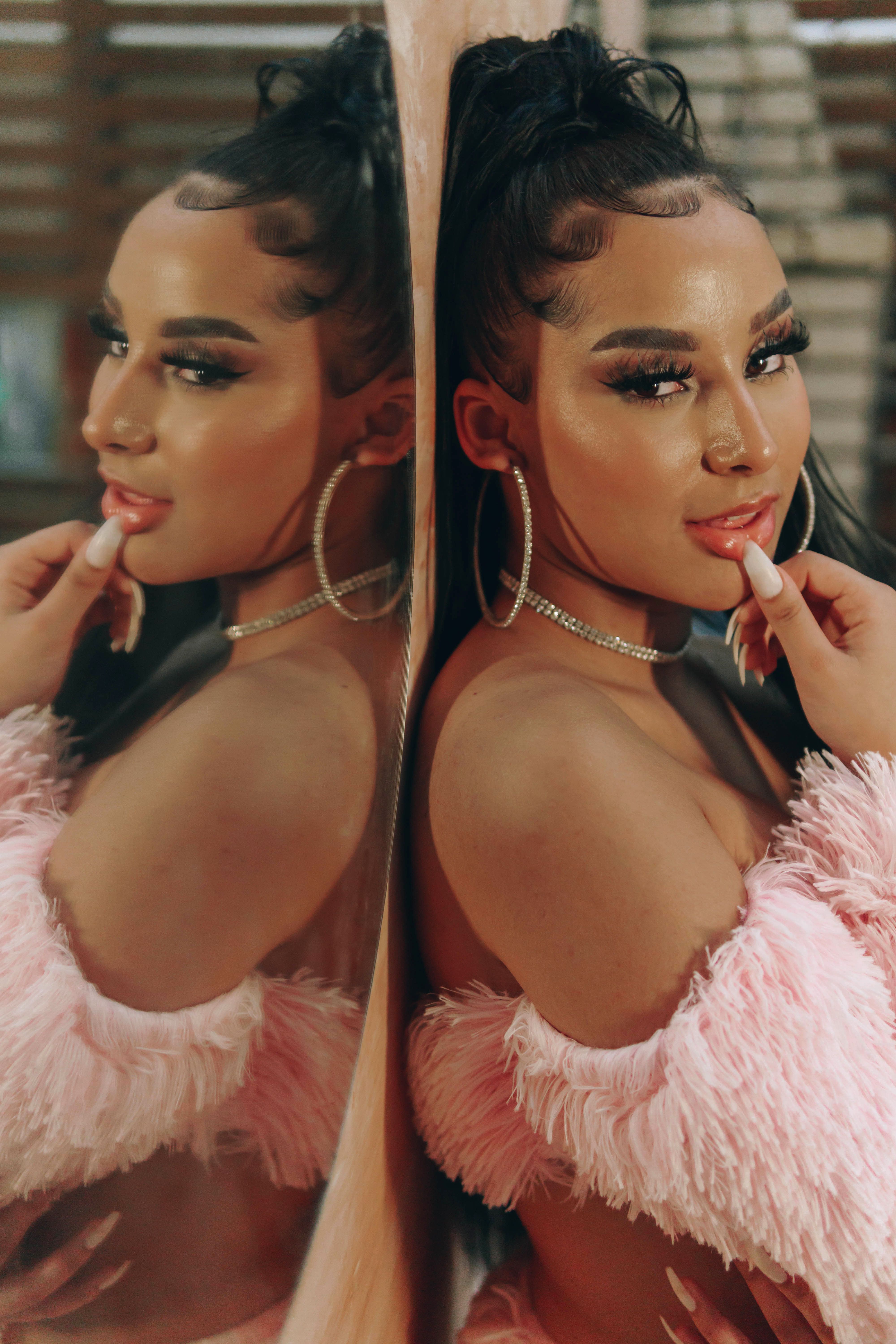 Stylish woman in pink fur posing by mirror with reflection in São Paulo.