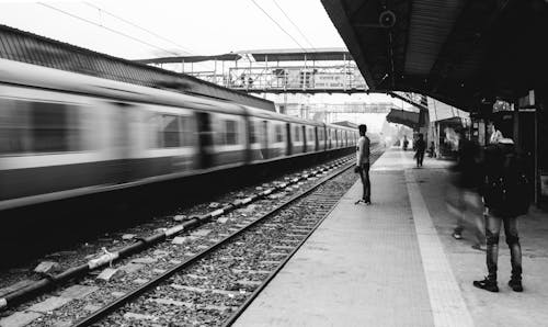 Grayscale Photo of People Standing on Train Station 