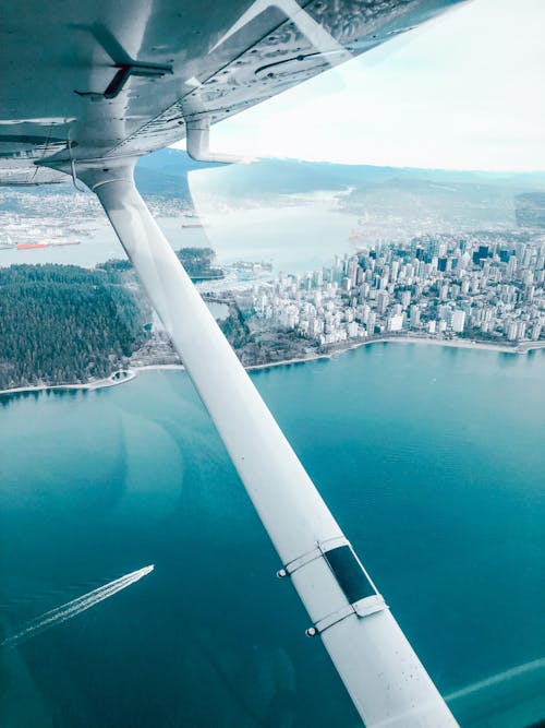 City and Sea Coast under Flying Airplane