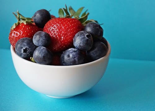 Arándanos Y Fresas En Cuenco De Cerámica Blanca