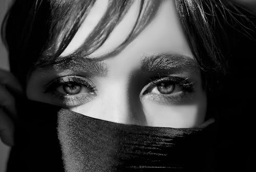 Free Woman Covering Half of Her Face with Fabric while Looking at the Camera Stock Photo