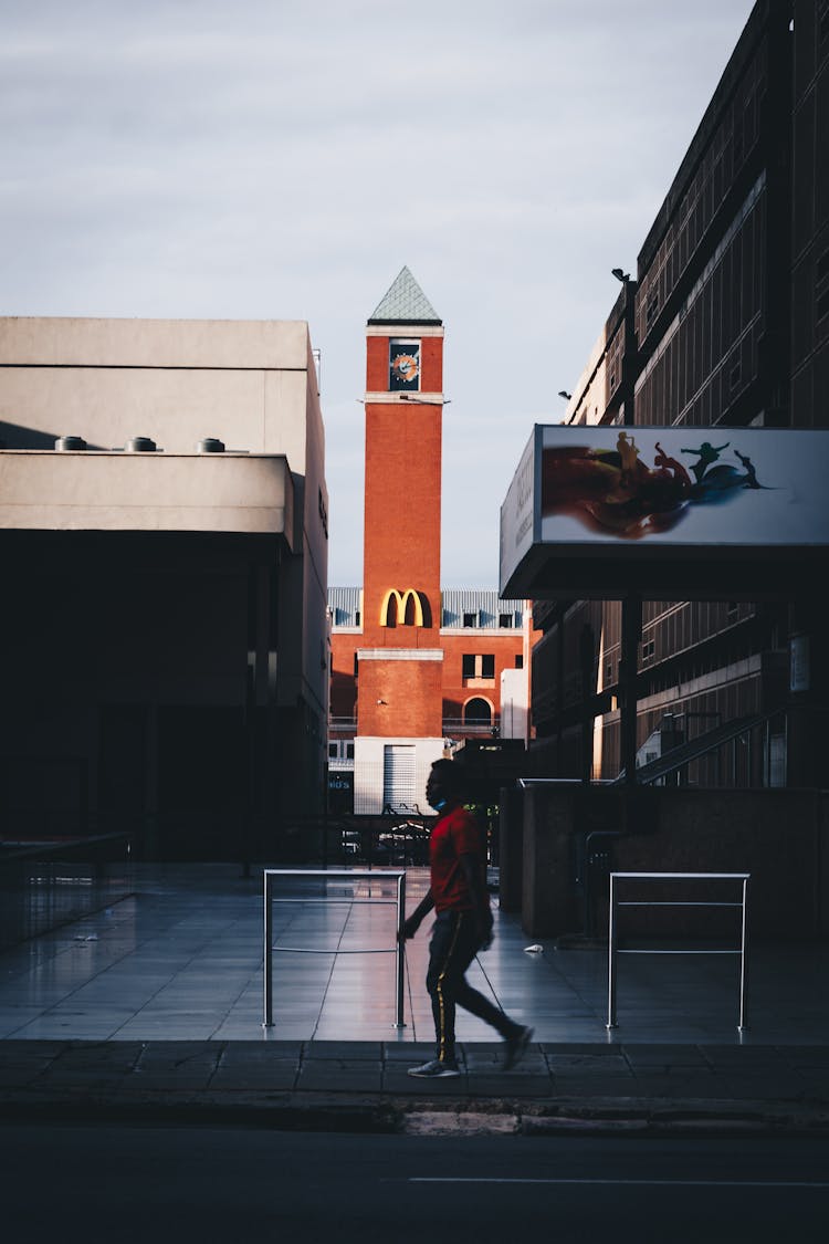 Man Walking Past McDonald's Sign