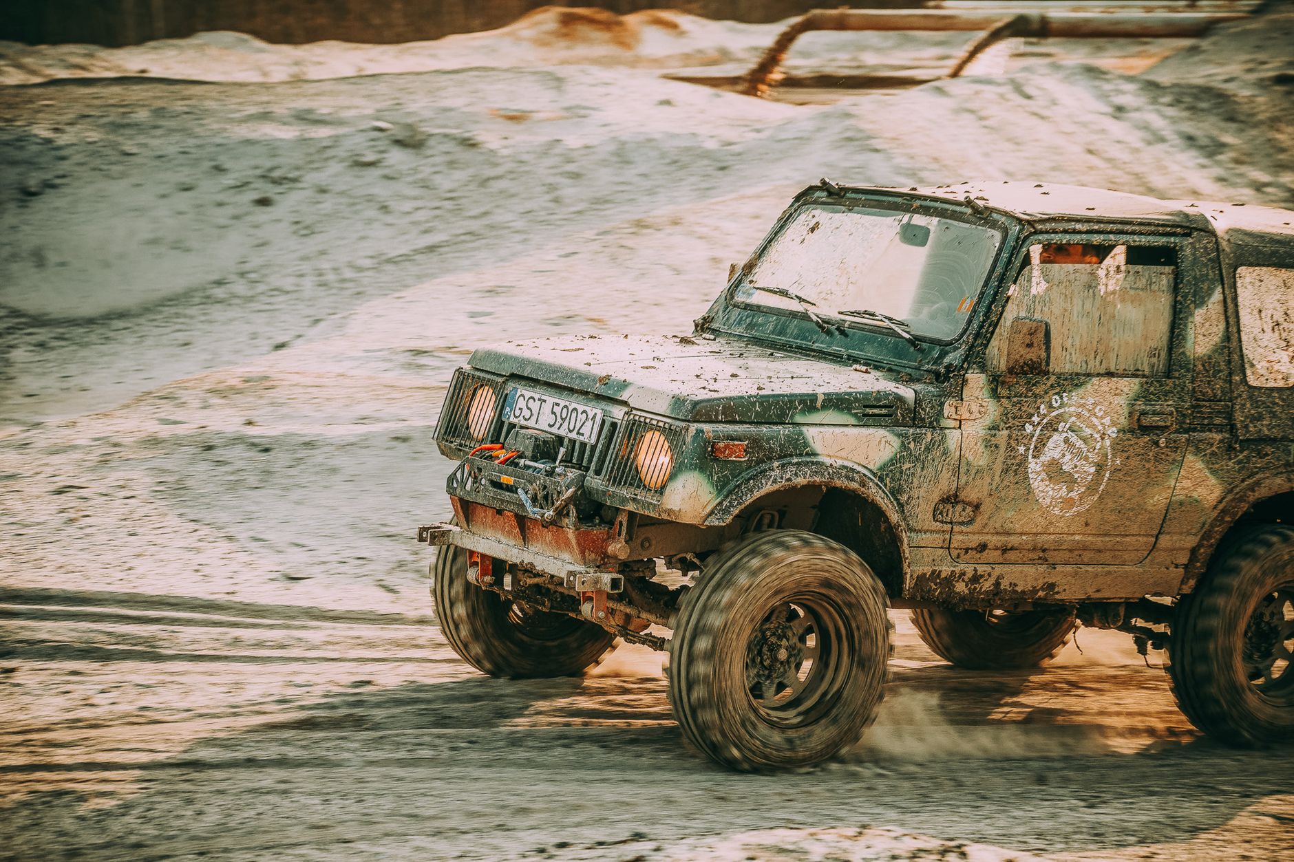 4x4 vehicle driving through sandy terrain, showcasing rugged off-road capabilities.