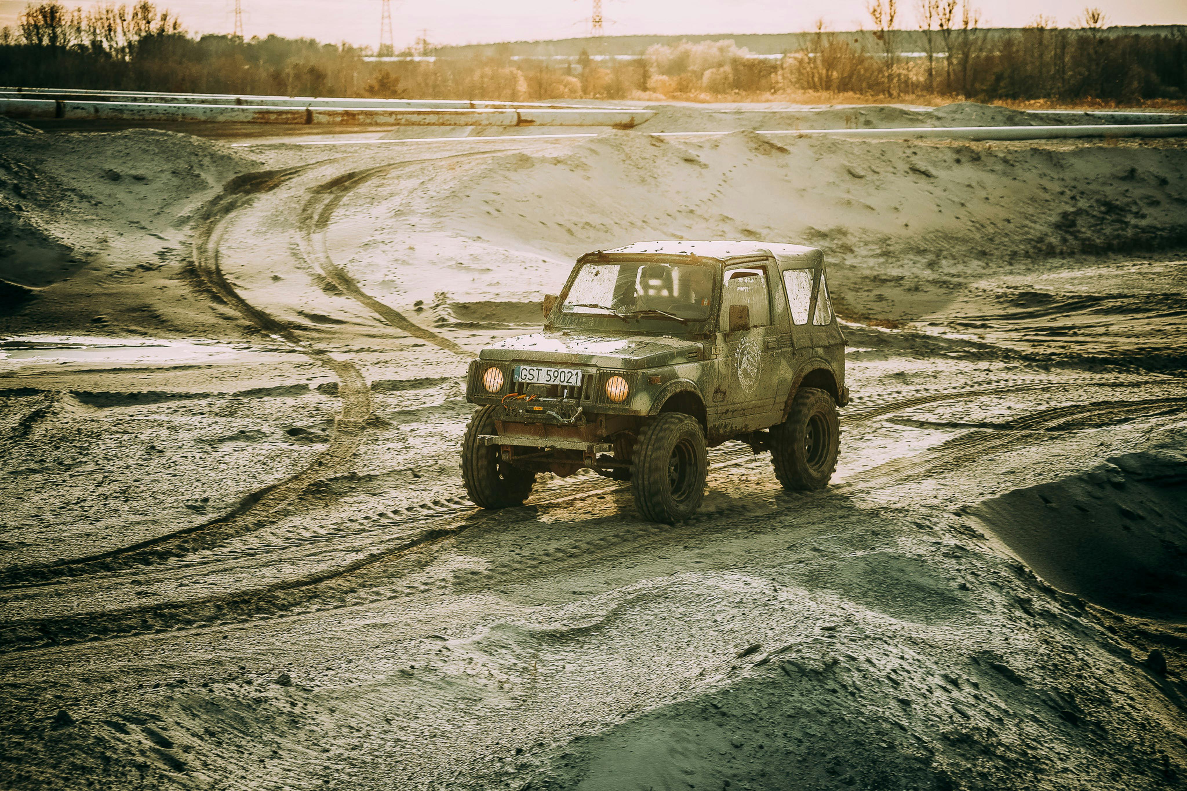 A rugged 4x4 vehicle navigating a muddy and challenging offroad terrain in Poland, capturing a sense of adventure.