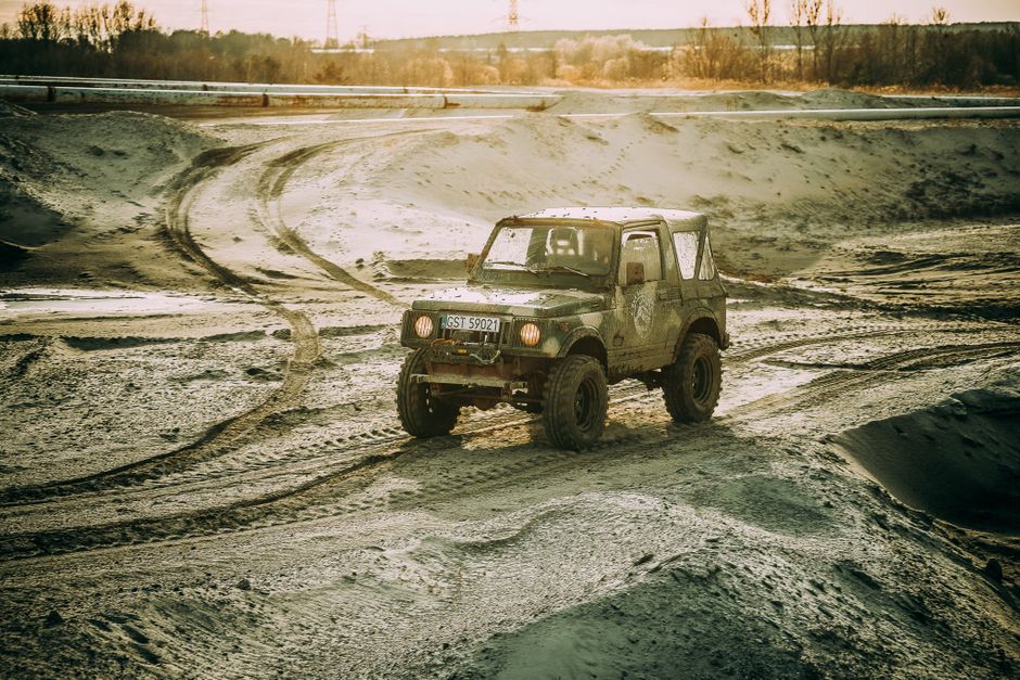 A rugged 4x4 vehicle navigating a muddy and challenging offroad terrain in Poland, capturing a sense of adventure.