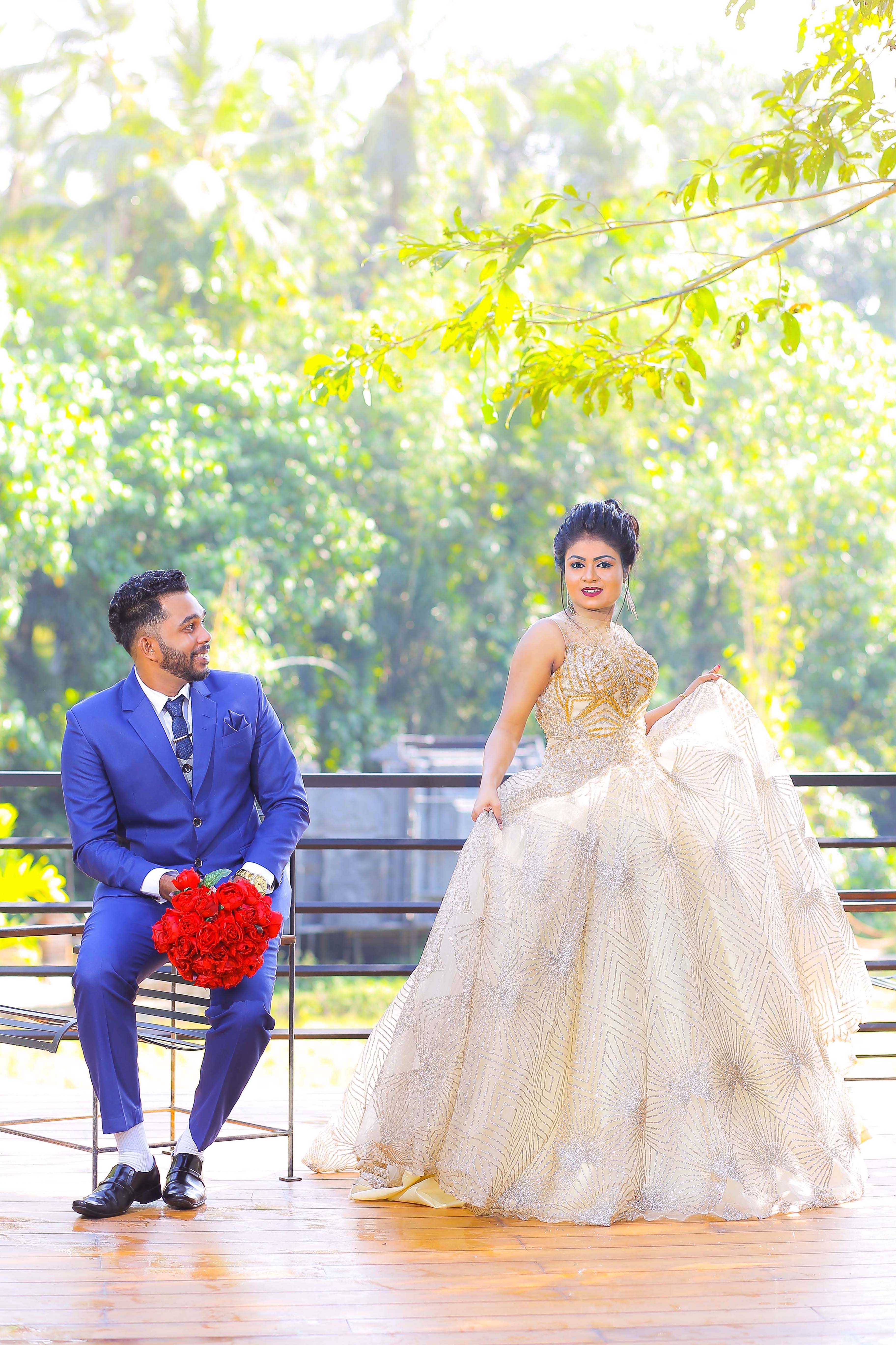 A newlywed couple poses gracefully in a lush Sri Lankan garden setting.