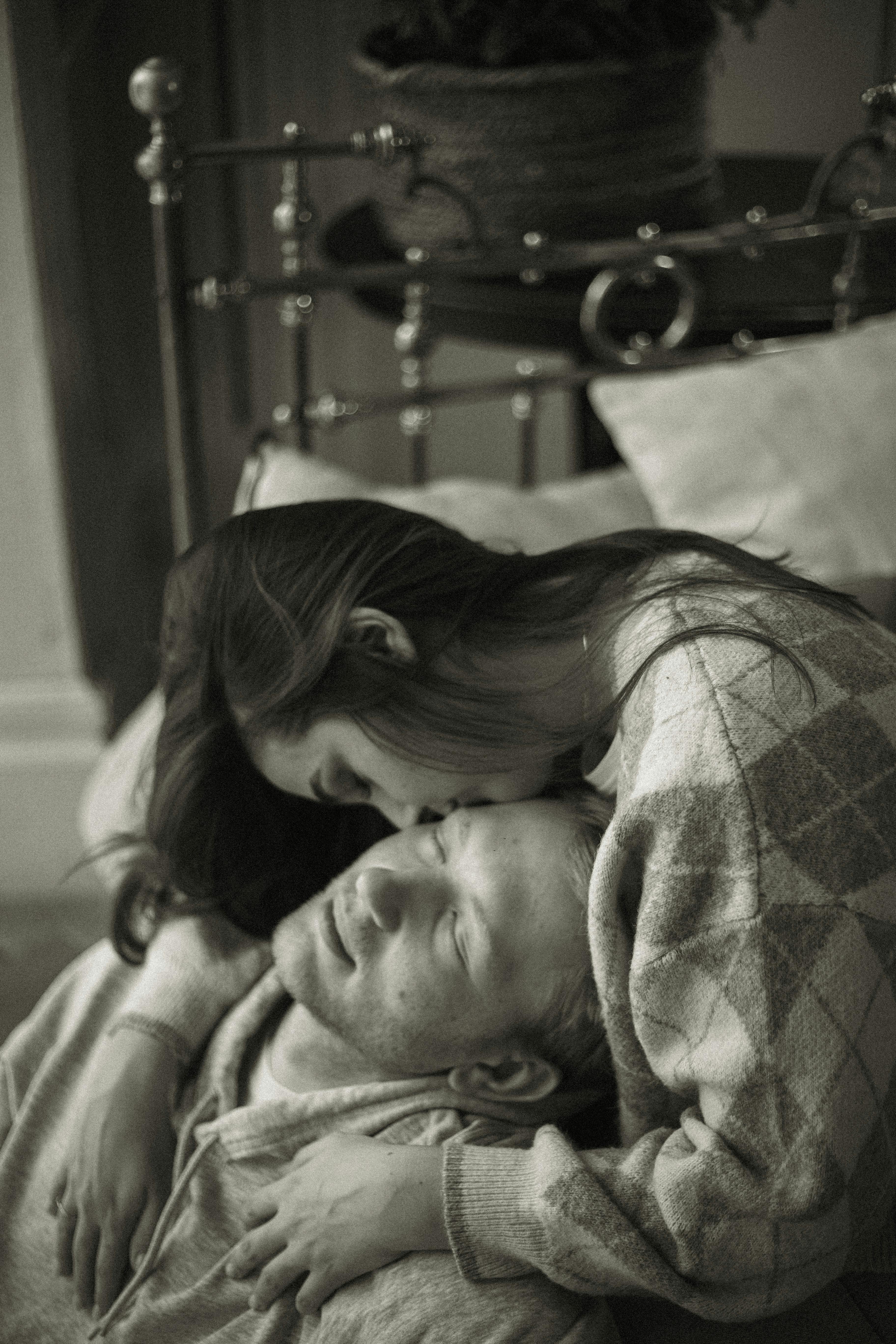 Foto gratuita di abbraccio, affetto, amore, baciando, bacio, bellissimo,  bianco e nero, coppia, donna, insieme, interni, occhi chiusi, relazione,  scala di grigi, seduto, storia d'amore, tiro verticale, uomo