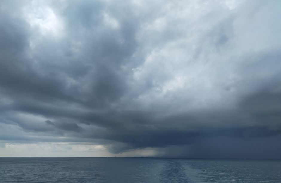 Captivating view of dark clouds forming over a calm ocean, enhancing the dramatic skyline.