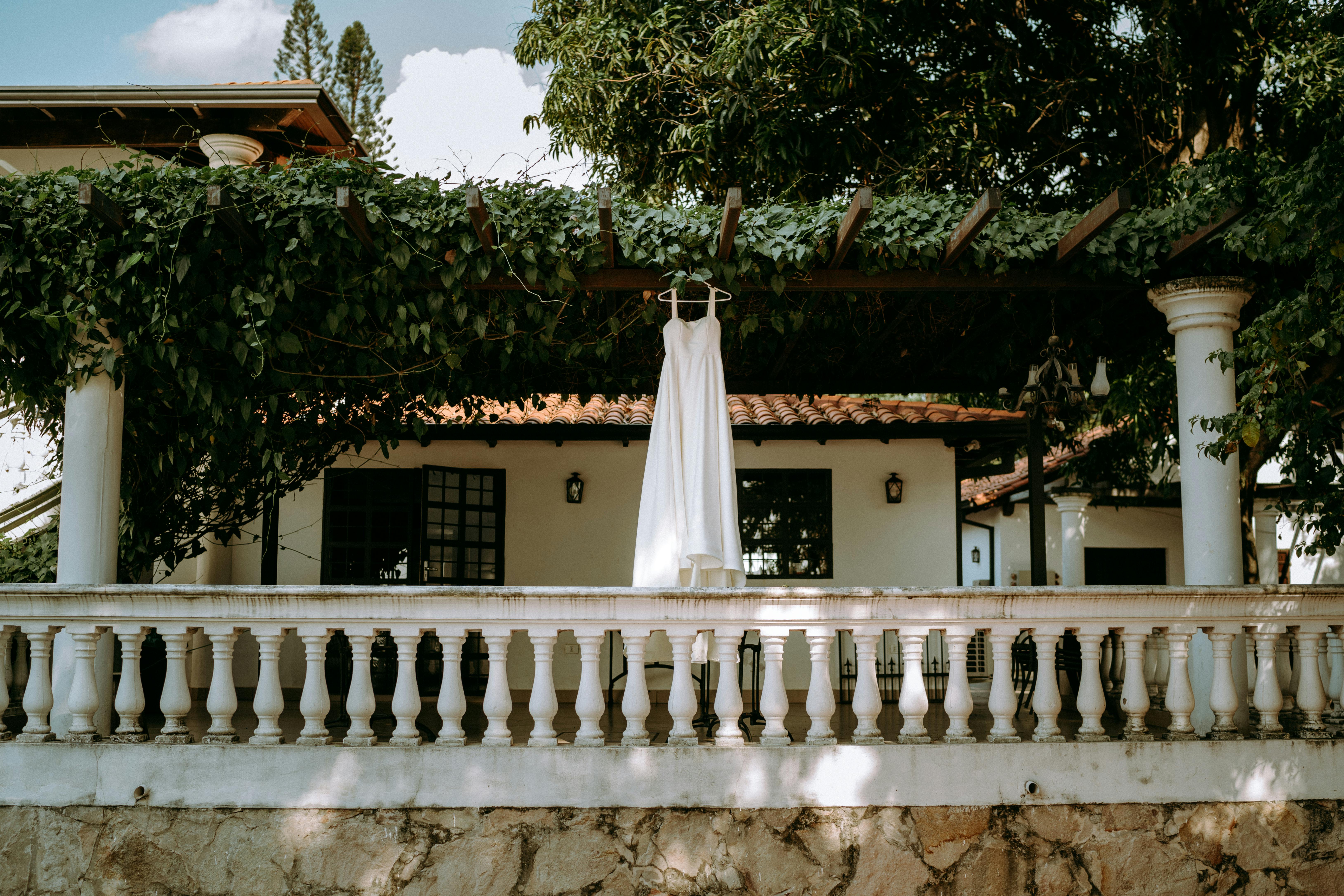 a white dress hanging on the trellis