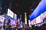 纽约市时代广场热闹非凡，明亮的数字广告牌和熙攘的人群将其照亮