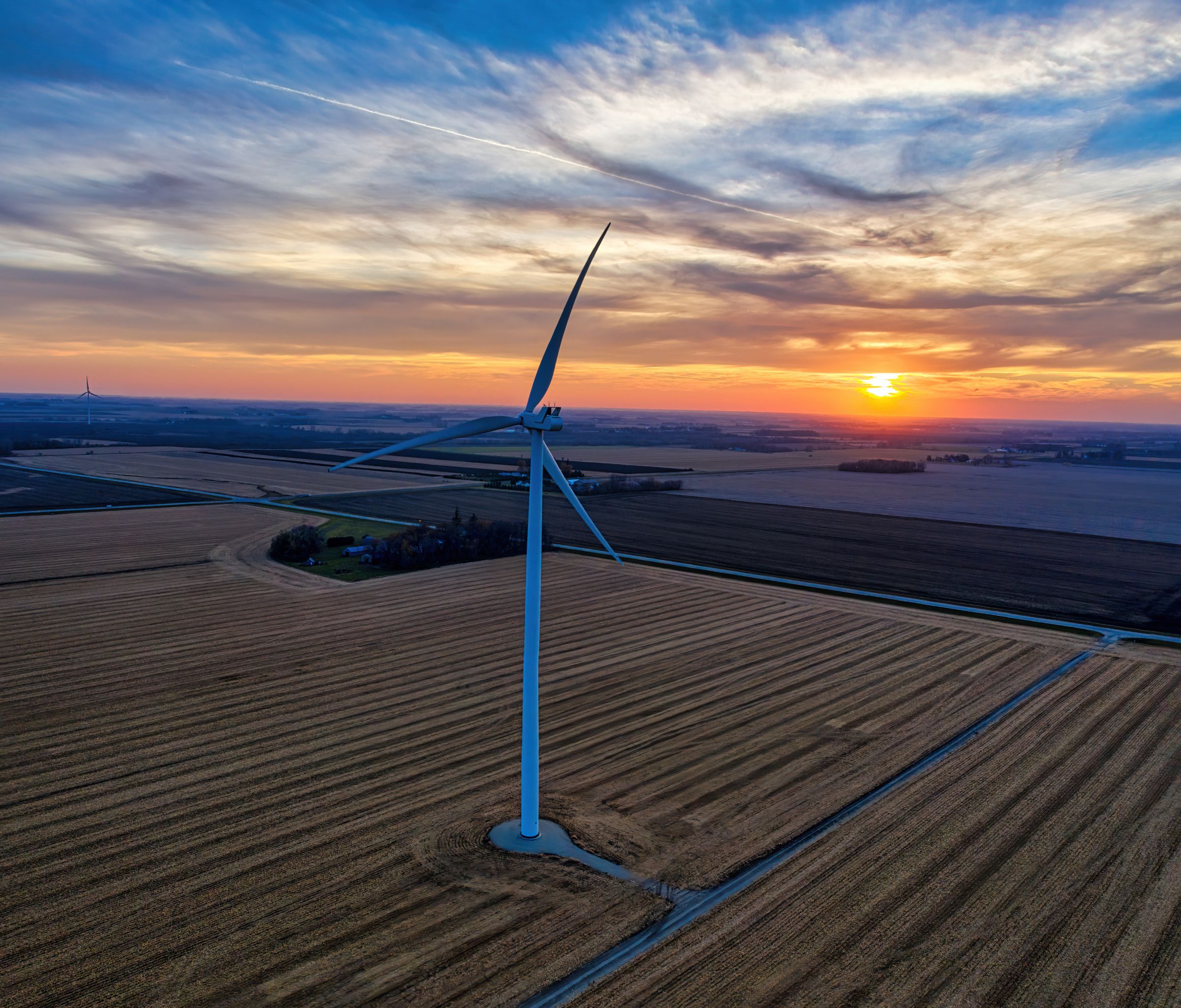 Wind turbine over Minnesota farmland at sunset