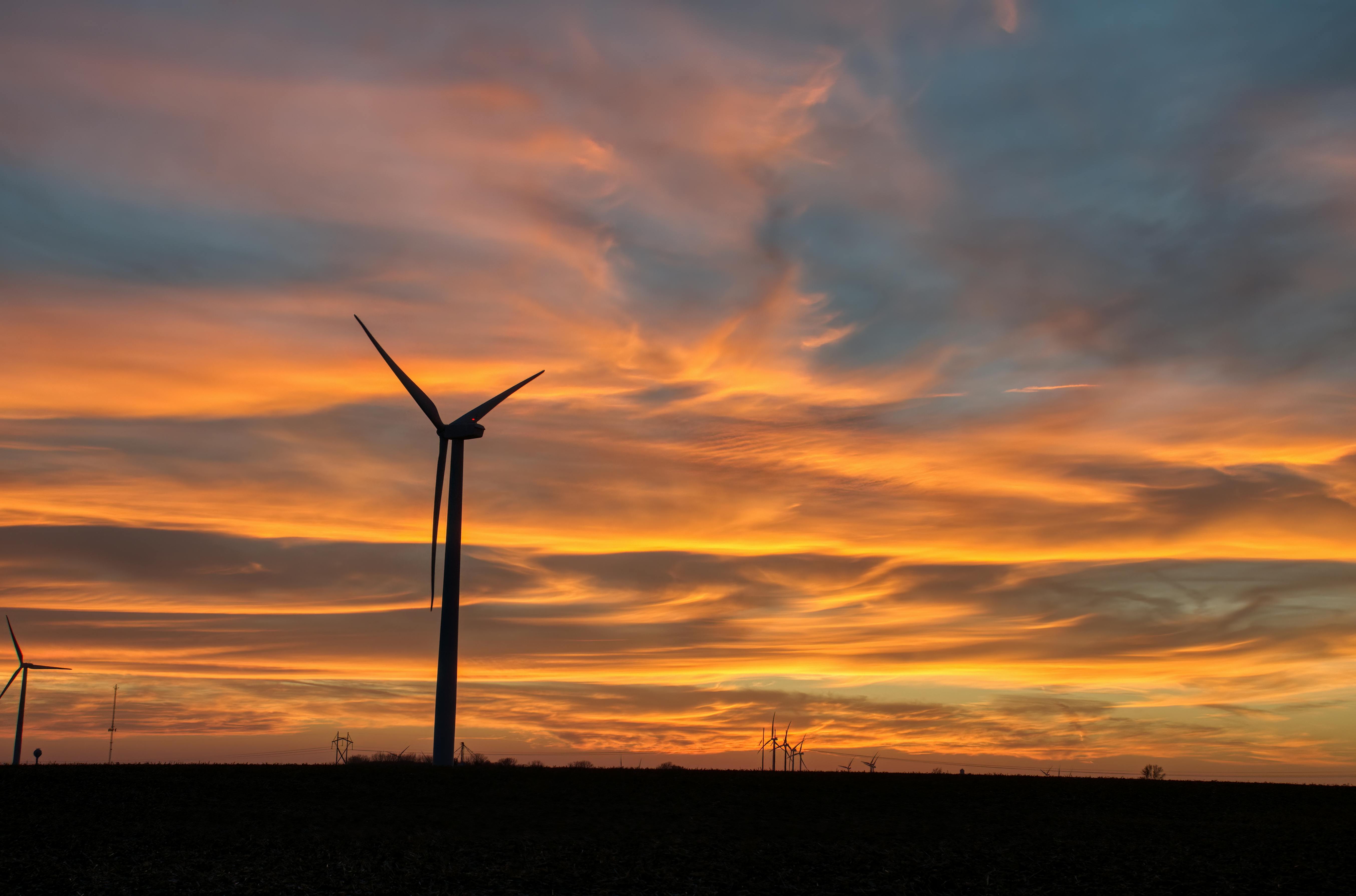 Wind turbines against a sunset